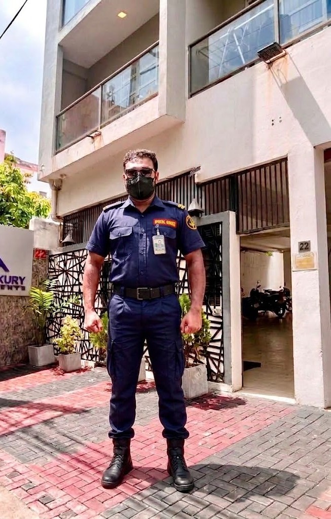 Special Guard officer standing at the entrance of an apartment building